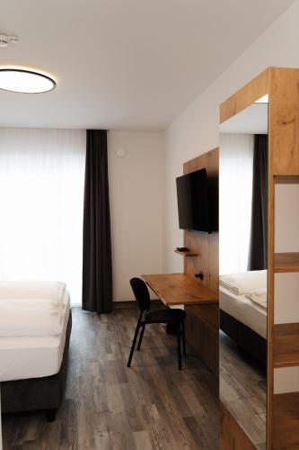 a hotel room with a desk and a bed at ML Business Hotel - Self-Check-in in Lannach