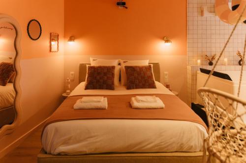 a bedroom with a large bed with two towels at La Pimenta - SPA privatif & expérience immersive in Dole