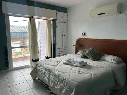 a bedroom with a bed and a large window at Lass Cahuelas in Federación