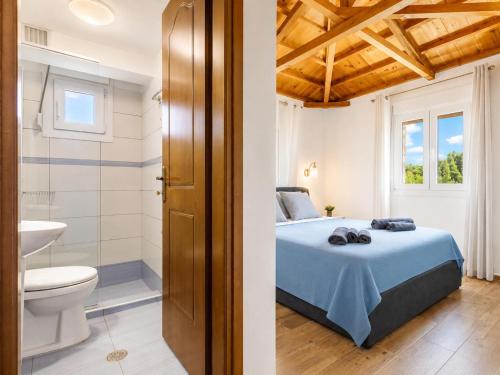 a bedroom with a bed and a bathroom at Oak Tree Cottage in Pefkias