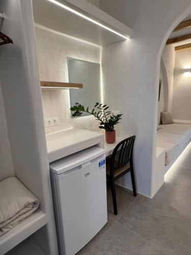 a small room with a small refrigerator and a chair at Golden Star in Ios Chora