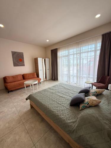 a bedroom with a large bed and a couch at NM Residence 2 in Shkorpilovtsi