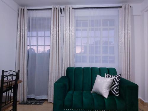 a green couch in a living room with a window at Nest homes in Eldoret