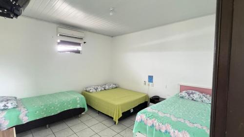 a room with two beds in a room at Pousada Zambaiam in Torto