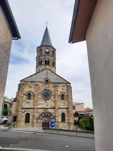 an old stone church with a clock tower at Maison du vigneron Saint-Martin in Cournon-dʼAuvergne