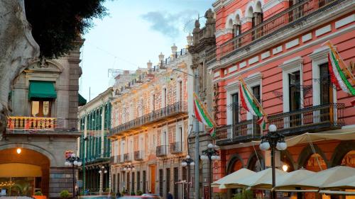 a group of buildings with flags in a street at Hotel Nube, Puebla Centro in Puebla