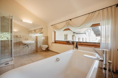 a bathroom with a tub and a sink and a toilet at Gasthaus Murauer in Simbach am Inn