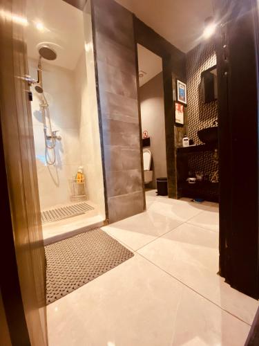a bathroom with a shower with a glass door at Corfu port apartment in Mantoúkion