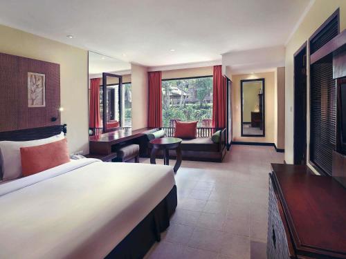a hotel room with a bed and a desk at Mercure Resort Sanur in Sanur