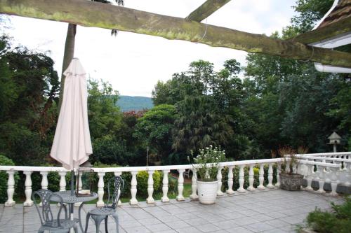 a patio with an umbrella and two chairs and a table at A Garden Suite B&B in Pietermaritzburg
