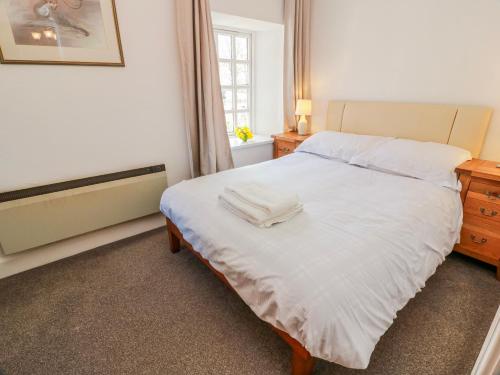 a bedroom with a white bed and a window at The Old Coach House in Lockerbie
