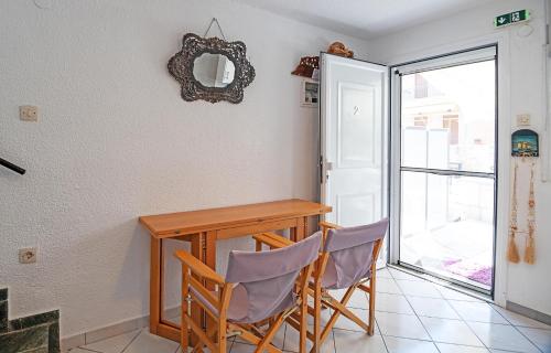 a dining room table with two chairs and a mirror at Big Blue Pefkohori in Pefkochori