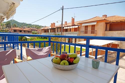a bowl of fruit on a table on a balcony at Big Blue Pefkohori in Pefkochori