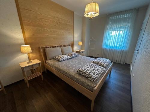 a bedroom with a bed and two lamps and a window at Babite Quiet Apartment in Babīte