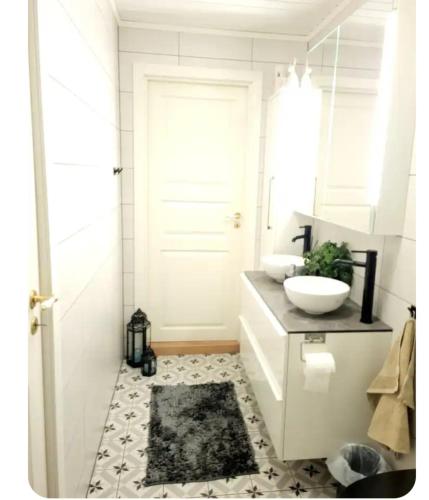 a white bathroom with a sink and a mirror at Casa Peace in Mysen