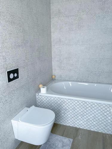 a bathroom with a white tub and a toilet at Suite 10 in Windhoek