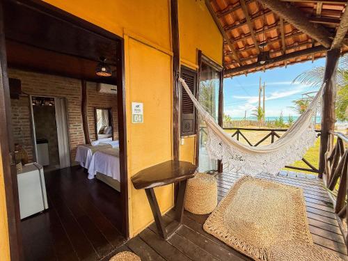 a room with a hammock and a bedroom at Vila Riomar in Luis Correia
