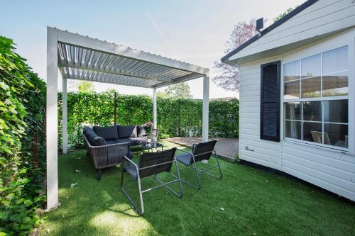 a patio with a couch and a table and chairs at 89, Beekse Bergen, Efteling, Nature, Kampina in Oisterwijk