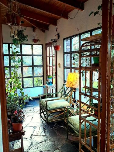 a room with chairs and a table and windows at Hotel Melipal in San Carlos de Bariloche