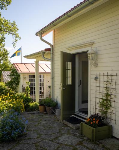 a house with a green door and some flowers at Stenkullens gårdshus in Borensberg