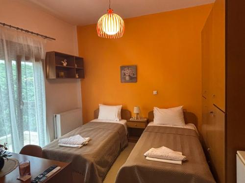 two beds in a room with orange walls at Catherine Seaside Apartment in Ouranoupoli