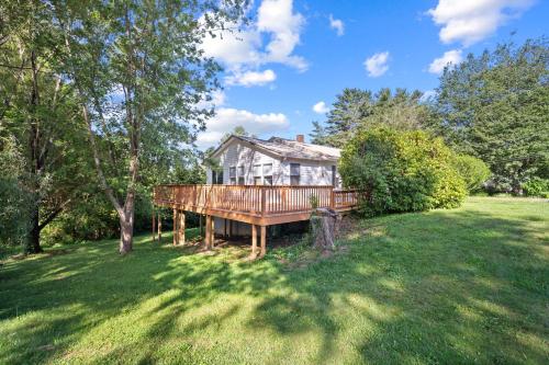 a house with a deck in a yard at Little Elves Overlook in Sparta