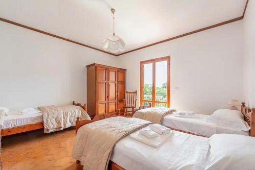 a room with three beds and a window at Casa Yunger in Deiva Marina