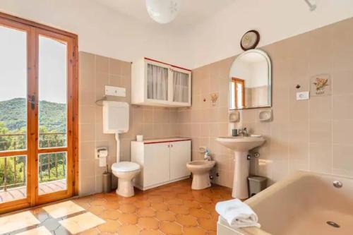 a bathroom with a tub and a toilet and a sink at Casa Yunger in Deiva Marina
