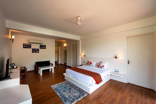 a bedroom with a large white bed and a couch at Tethys Himalaya Resort in Solan