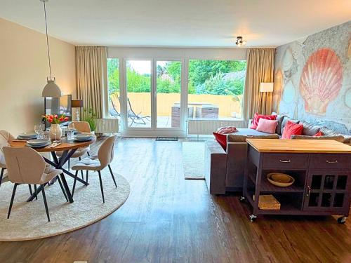 a living room with a table and a couch at Wahlheimat Haffkrug, Strandnaher Ostseeurlaub, Terrasse, Tiefgarage und WLAN in Scharbeutz
