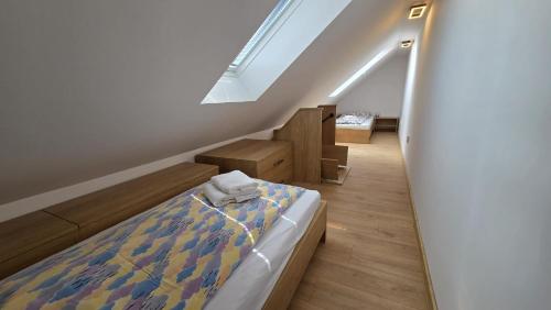 a attic bedroom with a bed and a staircase at Bytík Hlohovec Centrum in Hlohovec
