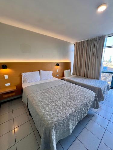 a hotel room with two beds and a window at Hotel Qamiri in Arica
