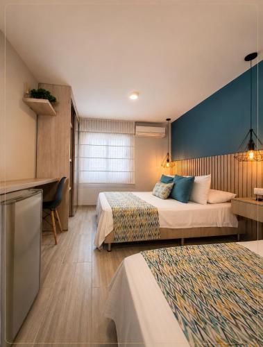 a hotel room with two beds and a desk at Hotel Quinta de Cabecera in Bucaramanga