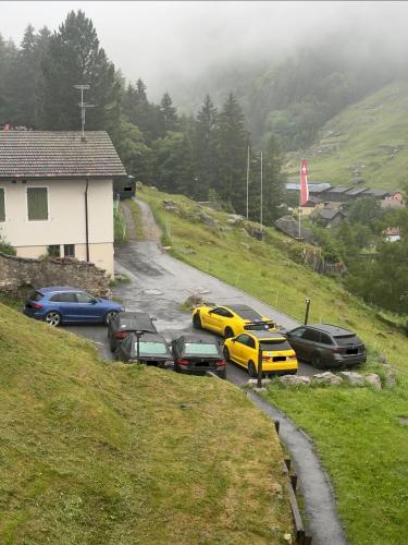 a group of cars parked in a parking lot on a hill at Blue Sky Apartments in Göschenen