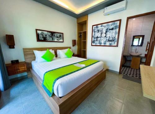 a bedroom with a large bed and a bathroom at Green Bali Guest House in Munggu