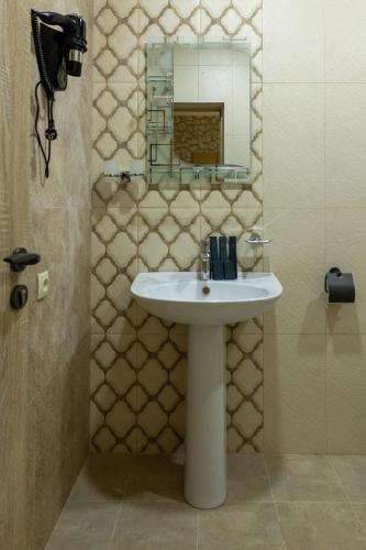a bathroom with a sink and a mirror at Old House Residence Aghveran & Restaurant in Arzakan