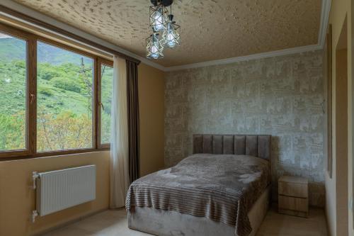 a bedroom with a bed and two windows at Old House Residence Aghveran & Restaurant in Arzakan
