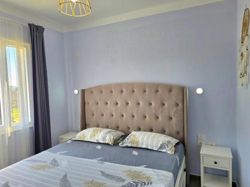 a bedroom with a bed with a blue wall at Wide Beach Apartments 236 in Mullini i Danit