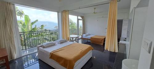 a room with two beds and a balcony with a view at Mist Farm Resort in Avanāshi