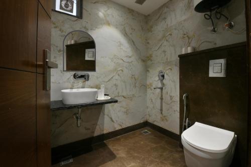 a bathroom with a toilet and a sink and a mirror at Hotel Namaskar India - Just A Minute Away From New Delhi Railway Station & Connaught Place in New Delhi