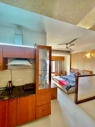 a bedroom with a bed and a kitchen with a counter at ZenRoofs - Brij Bhumi Haven 1 in Vrindāvan