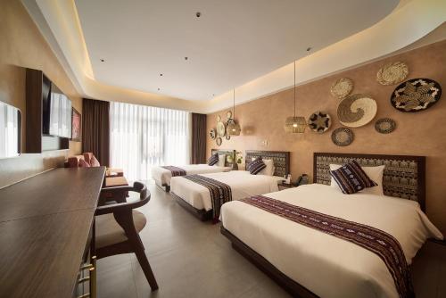 a hotel room with three beds and a desk at Duyên Hùng Premier Hotel in Diện Biên Phủ
