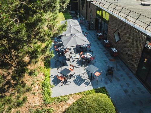 an overhead view of a patio with tables and umbrellas at Mercure Caen Cote De Nacre in Caen