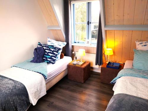 a small room with two beds and a window at Het Vissershuisje in Edam