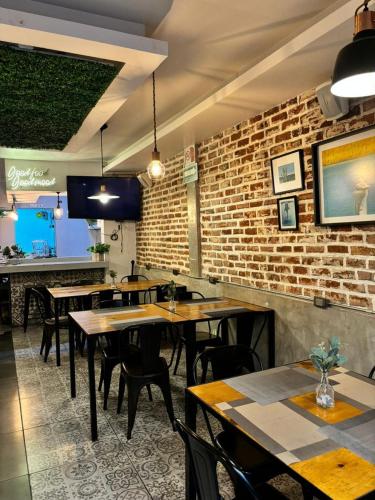 a restaurant with tables and chairs and a brick wall at Hotel Miramar - La Paz in La Paz