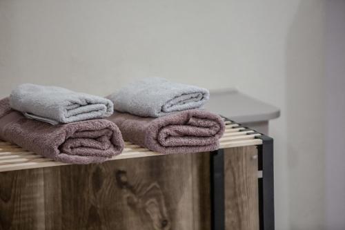 a pile of towels sitting on top of a wooden shelf at ZoYa`s Apartments in Agria