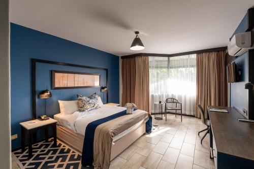 a bedroom with blue walls and a bed in a room at Indaba Lodge Hotel Richards Bay in Richards Bay