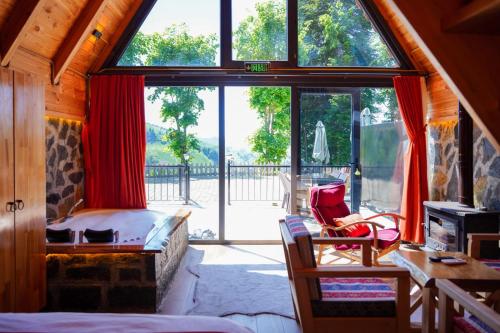 a bedroom with a large window and a bed and a desk at Doğallife suit bungalow in Çamlıhemşin