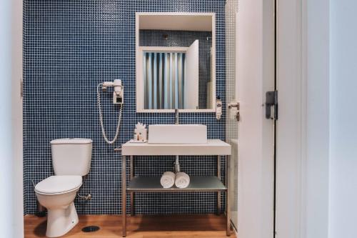 a bathroom with a toilet and a sink and a mirror at Hotel Flor De Sal by The Editory in Viana do Castelo