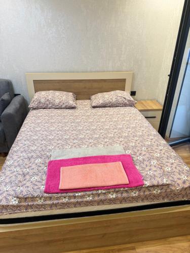 a bedroom with a bed with a pink blanket on it at Fantastico 270 in Batumi